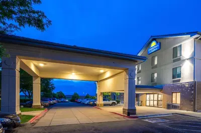 a hotel building with a parking lot at Days Inn & Suites by Wyndham Denver International Airport in Denver
