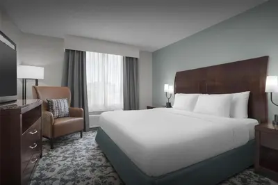 a hotel room with a large bed and a chair at Hilton Garden Inn Denver Highlands Ranch in Highlands Ranch