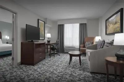 a hotel room with a couch and a tv at Hilton Garden Inn Denver Highlands Ranch in Highlands Ranch