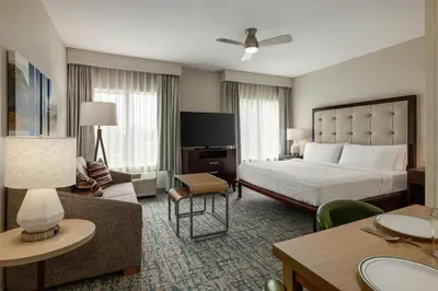 a hotel room with a bed and a living room at Homewood Suites by Hilton Denver West - Lakewood in Lakewood