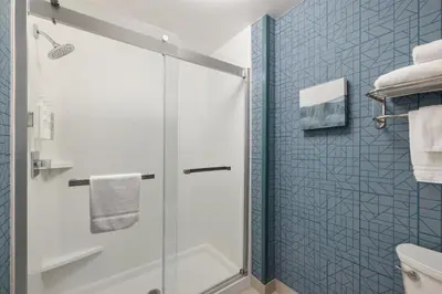 a bathroom with a shower with blue tiles at Homewood Suites by Hilton Denver West - Lakewood in Lakewood