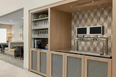 a lobby with a bar with a tv on a wall at Homewood Suites by Hilton Denver West - Lakewood in Lakewood