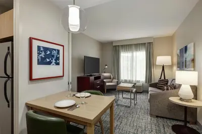 a living room with a table and a living room with a couch at Homewood Suites by Hilton Denver West - Lakewood in Lakewood