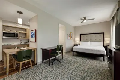 a hotel room with a bed and a desk and a kitchen at Homewood Suites by Hilton Denver West - Lakewood in Lakewood