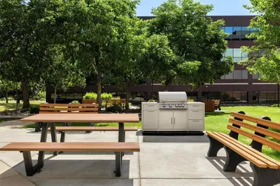 a picnic table and benches with a grill in a park at Homewood Suites by Hilton Denver West - Lakewood in Lakewood