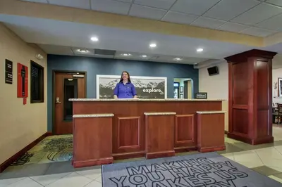 a woman standing at a counter in a waiting room at Hampton Inn & Suites Denver Littleton in Littleton