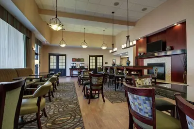 a restaurant with tables and chairs and a bar at Hampton Inn & Suites Denver Littleton in Littleton