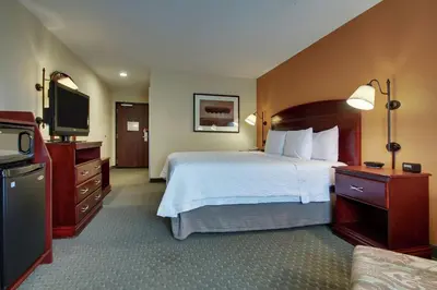 a hotel room with a bed and a flat screen tv at Hampton Inn & Suites Denver Littleton in Littleton