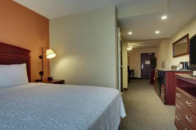 a hotel room with a bed and a bathroom at Hampton Inn & Suites Denver Littleton in Littleton