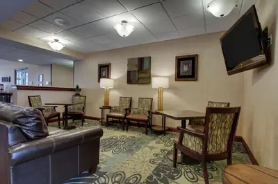 a waiting room with a couch and a tv at Hampton Inn & Suites Denver Littleton in Littleton