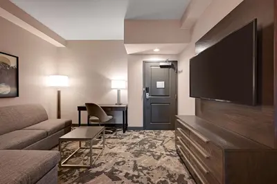 a living room with a couch and a flat screen tv at DoubleTree by Hilton Denver International Airport, CO in Denver
