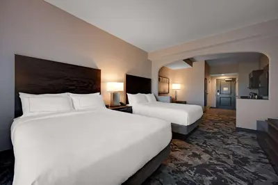 two beds in a hotel room with white sheets at DoubleTree by Hilton Denver International Airport, CO in Denver