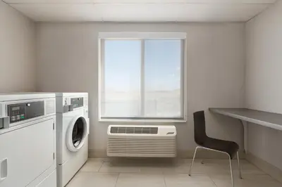 a laundry room with a washing machine and a window at Holiday Inn Express & Suites Denver Airport by IHG in Denver