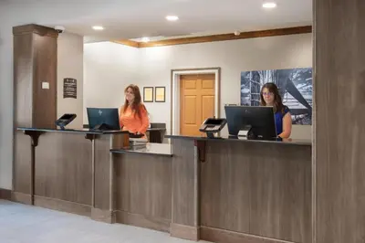 two women standing at a reception counter in a waiting room at Staybridge Suites Denver International Airport by IHG in Denver