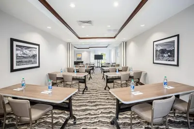 a conference room with tables and chairs and a podium at Staybridge Suites Denver International Airport by IHG in Denver