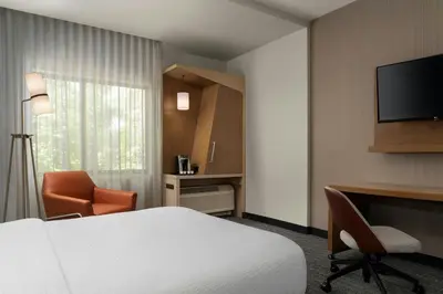 a hotel room with a bed and a desk and a television at Courtyard by Marriott Denver North/Westminster in Eastlake