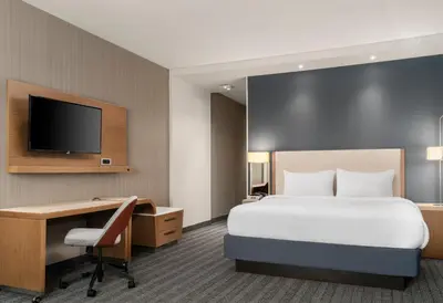 a hotel room with a bed and a desk and a tv at Courtyard by Marriott Denver North/Westminster in Eastlake