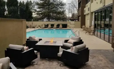 a swimming pool with chairs and a table and a table and a tablektop at Holiday Inn Denver Lakewood by IHG in Lakewood