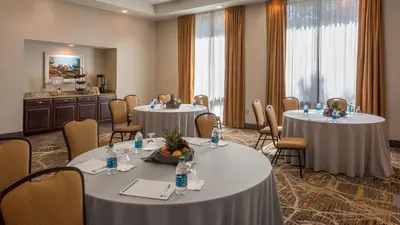 a conference room with two round tables and chairs at Holiday Inn Denver Lakewood by IHG in Lakewood