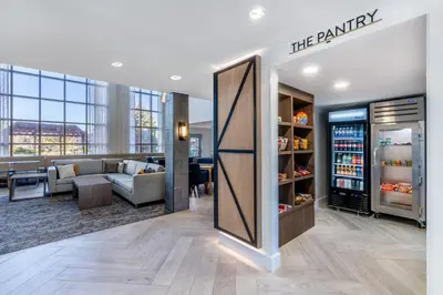 an office lobby with a refrigerator and a couch at Staybridge Suites Denver - Cherry Creek by IHG in Denver