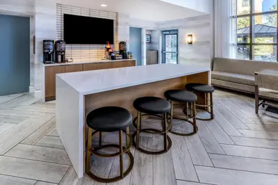 a lobby with a bar with stools around it at Staybridge Suites Denver - Cherry Creek by IHG in Denver