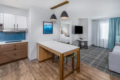 a kitchen and living room with a table and a couch at Staybridge Suites Denver - Cherry Creek by IHG in Denver