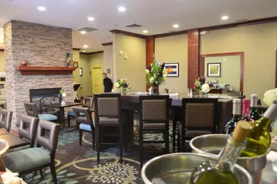 a dining room with a fireplace and a table and chairs at Staybridge Suites Denver Tech Center by IHG in Centennial