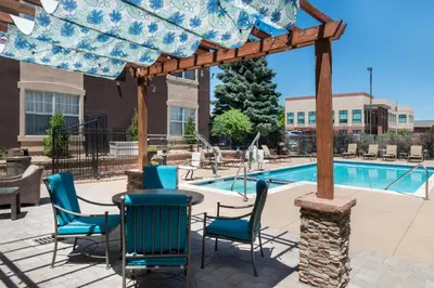 a patio with a table and chairs next to a pool at Staybridge Suites Denver Tech Center by IHG in Centennial