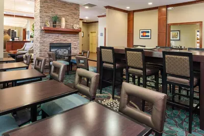a restaurant with tables and chairs and a fireplace at Staybridge Suites Denver Tech Center by IHG in Centennial