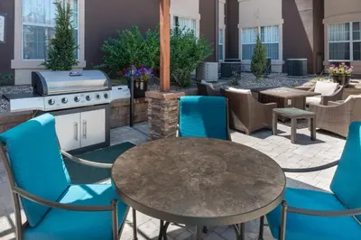 a patio with a table and chairs and a grill at Staybridge Suites Denver Tech Center by IHG in Centennial