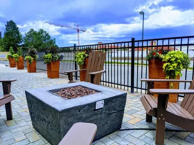 a fire pit with two chairs and a fence at EVEN Hotels Denver Tech Center-Englewood by IHG in Centennial