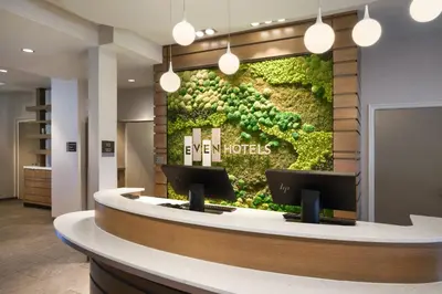 a lobby with a sign on the wall with a green wall at EVEN Hotels Denver Tech Center-Englewood by IHG in Centennial