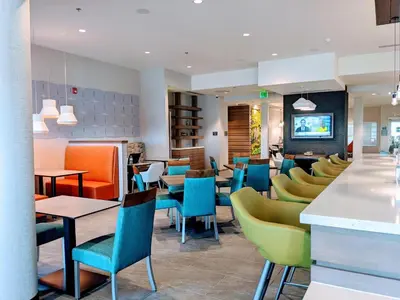 a restaurant with colorful chairs and tables at EVEN Hotels Denver Tech Center-Englewood by IHG in Centennial