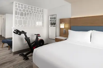a bedroom with a bed and a scooter in a room at EVEN Hotels Denver Tech Center-Englewood by IHG in Centennial