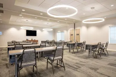 a conference room with tables and chairs and a screen at EVEN Hotels Denver Tech Center-Englewood by IHG in Centennial