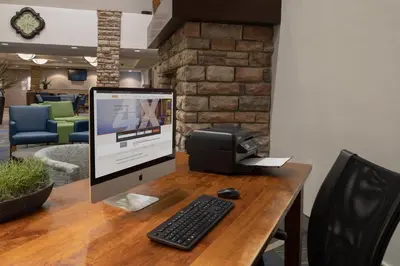 an office desk with a computer monitor and a printer at Holiday Inn Express Hotel & Suites Littleton by IHG in Littleton
