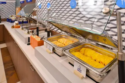 a buffet line with trays of food on display at Holiday Inn Express Hotel & Suites Littleton by IHG in Littleton