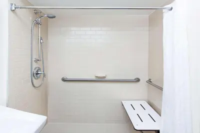 a bathroom with a shower with a toilet and a sink at Sonesta Simply Suites Denver West Federal Center in Lakewood
