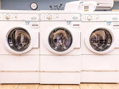 a pile of white washing machines in a laundry room at Sonesta Simply Suites Denver West Federal Center in Lakewood