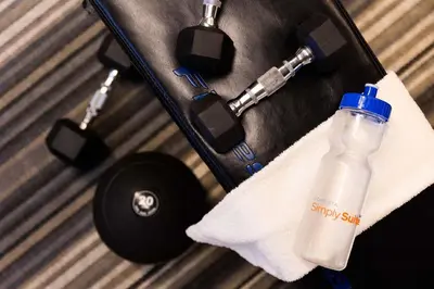 a bottle of water in a suitcase with a towel at Sonesta Simply Suites Denver West Federal Center in Lakewood