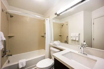 a bathroom with a sink and a tub and a toilet at Sonesta Simply Suites Denver West Federal Center in Lakewood