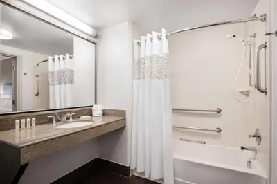 a bathroom with a sink and a shower with a shower curtain at Hampton Inn Loveland in Loveland