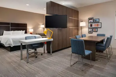 a hotel room with a bed and a desk and chairs at Hampton Inn Loveland in Loveland