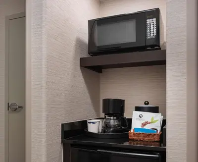 a microwave sitting on a shelf with a coffee maker at Hampton Inn Loveland in Loveland