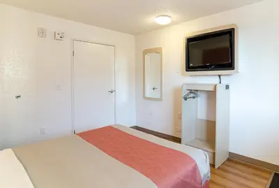 a small room with a bed and a flat screen tv at Motel 6- Denver, CO Downtown in Denver