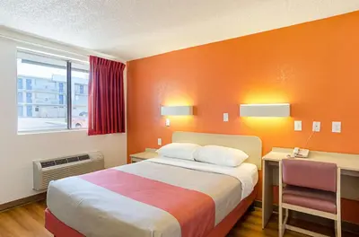 a bedroom with a bed and a desk and a window at Motel 6- Denver, CO Downtown in Denver