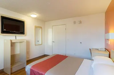 a hotel room with a bed and a flat screen tv at Motel 6- Denver, CO Downtown in Denver