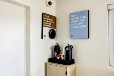 a room with a coffee maker on a wooden cabinet at Motel 6-Denver, CO - Airport in Denver