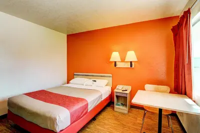 a hotel room with a bed and a desk and a window at Motel 6-Denver, CO - Airport in Denver