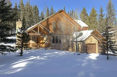a log home in the snow with trees at Keystone Private Homes by Vail Resorts in Keystone